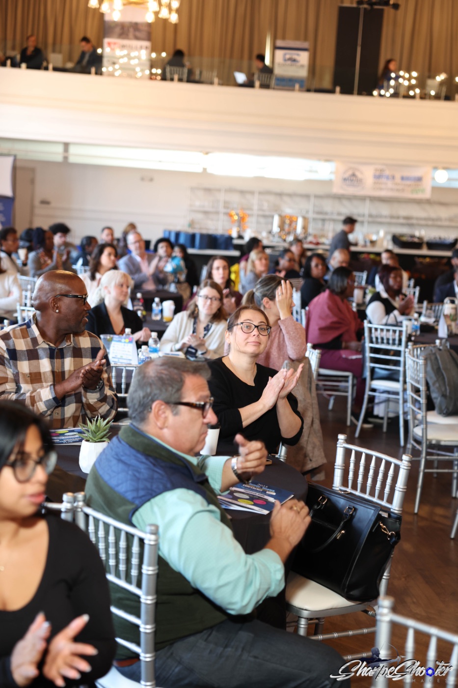 Attendees applauding during the opening session