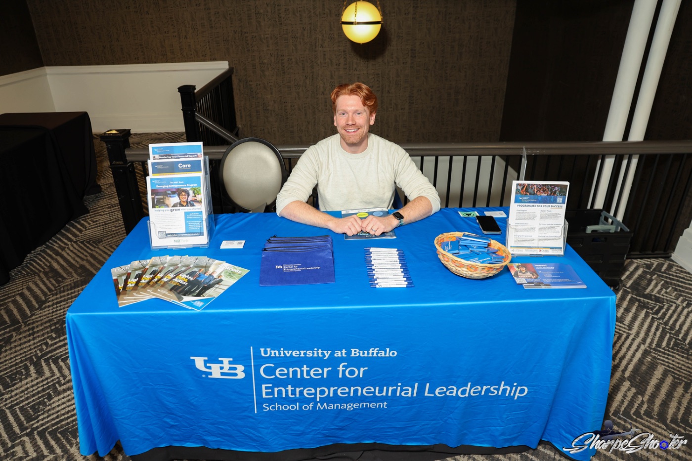 Exhibitor talking with attendees at their table