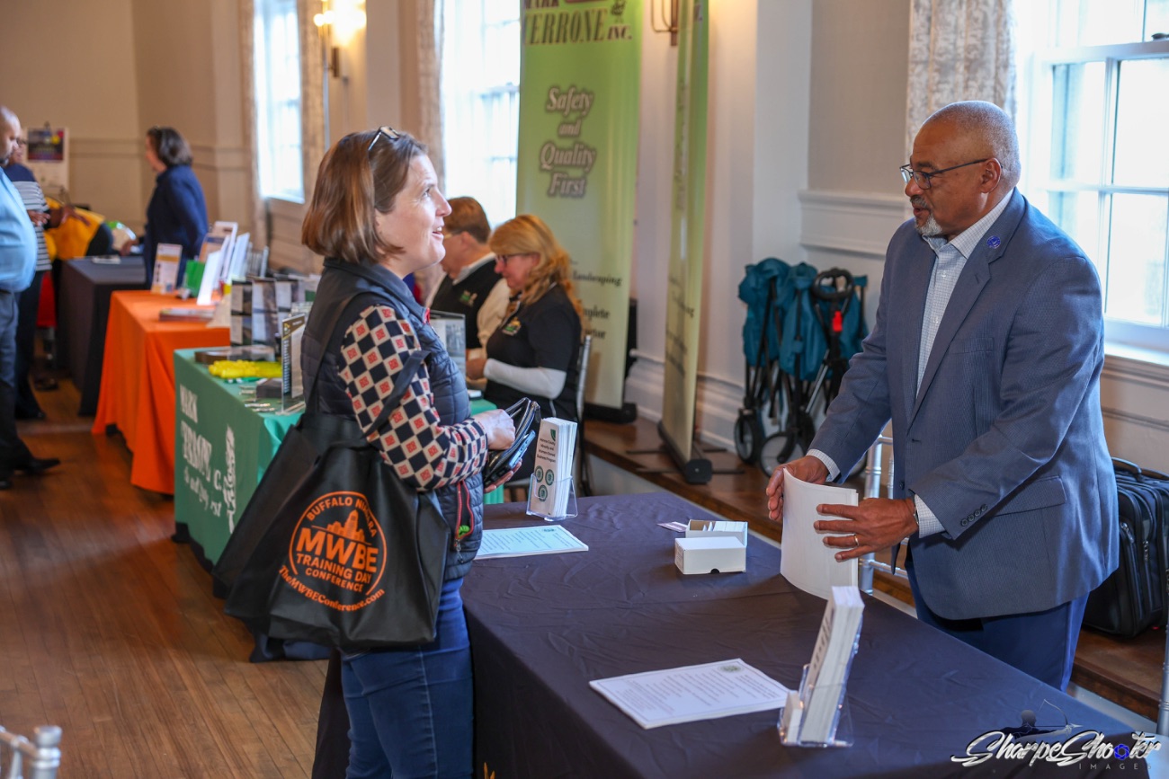 A business owner talking with an agency rep at an expo table